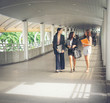 © Johnstocker - Businesswomen discussing over paperwork together against railing. Business people concept.