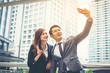 © Johnstocker - Young businessman and colleague outdoors in urban setting taking a selfie
