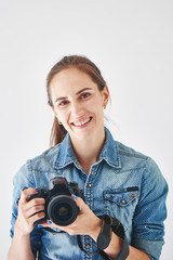 Portrait of a girl photographer on a white background