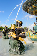 The Fountain Of The Seas In The Concorde Square In Paris, France, With Statues Of Nereids And Tritons Holding Golden Fishes Spitting Water Up To The Upper Basin.