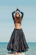 © zolotareva_elina - Attractive young woman in black dress on the beach. belly dancer. tribal fusion
