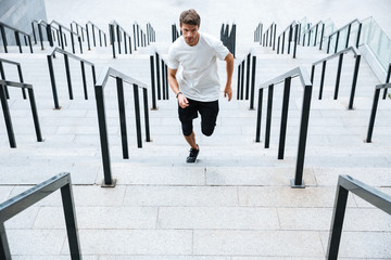 Wall Mural - Sports man running by ladder at the stadium