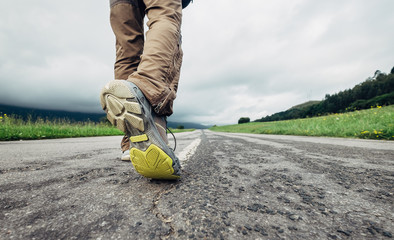 Wall Mural - traveler feet on the road close up image