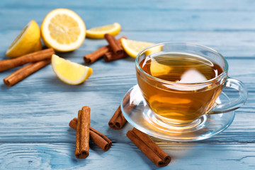 Poster - Cup with aromatic hot cinnamon tea and lemon on wooden table