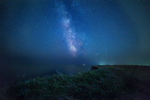 Night Photo. Milky Way On A Wild Cliff Near The Sea. Wild Wildflowers On A Precipice.
