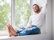 © GVS - Handsome smiling man relaxing on window sill