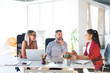 © Halfpoint - Three business people in the office talking together.
