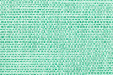 Light green background from a textile material with wicker pattern, closeup.