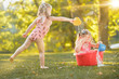 © master1305 - The cute little blond girls playing with water splashes on the field in summer