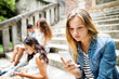 © Halfpoint - Teenage student girl with smart phone sitting on stone steps.