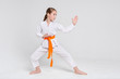 © Prostock-studio - Karate girl in kimono in stand at studio background
