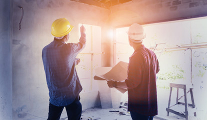 two construction engineers working together in side building planning for the renovation construction site engineer, effect Vintage sun flare.