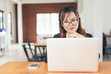 Wall Mural - Asian young business freelance woman happiness working online business with laptop and cell phone in cafe shop. Working concept.