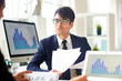 © pressmaster - Young economist talking to colleague and explaining financial papers