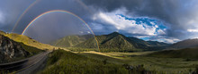 Panoramic View Of Bright Rainbows Over Railway Rails Between Green Hills 