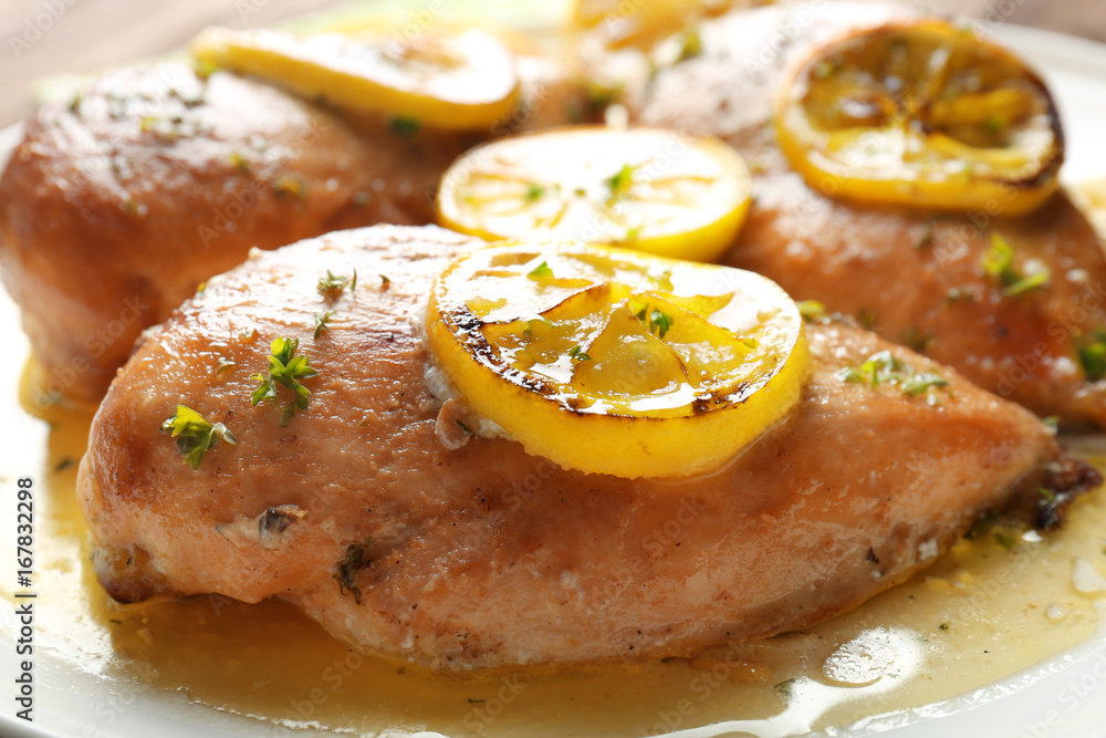 Delicious chicken breasts with lemon on plate, closeup
