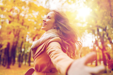 beautiful happy young woman walking in autumn park