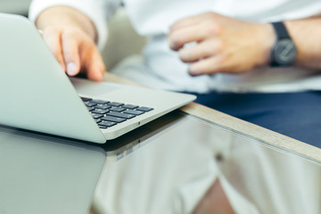 Young man performs work on a laptop