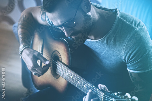 Plakat przystojny mężczyzna gra na gitarze akustycznej