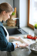 © lenets_tan - Beautiful woman cooking cake in kitchen standing near desk.