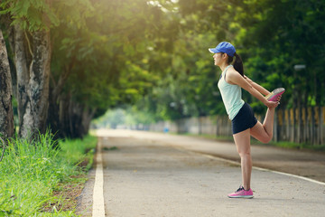 Young Healthy fitness woman runner stretching legs before running in the park.