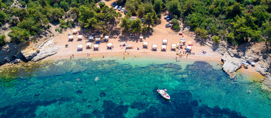 Wall Mural - Aerial view of sandy beach with sunbathing tourists and clear turquoise sea