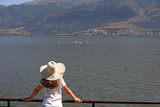 Fototapeta Dziecięca - The girl watches the swans on the lake Ioannina Greece