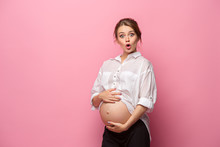 Young Beautiful Pregnant Woman Standing On Pink Background