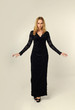 full length portrait of a blonde lady wearing black lace dress, standing pose, isolated against creamy studio background.