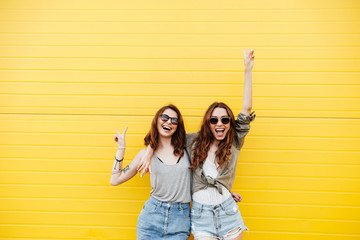 Poster - Young happy women friends standing over yellow wall