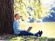 © lkoimages - Happy student study with laptop in city park
