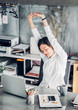 © weedezign - Asian businesswoman raise arm up stretching in front of desk from work on notebook screen in office,Office lifestyle concept