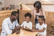 © LIGHTFIELD STUDIOS - african-american family looking at menu list in modern cafe