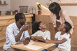 © LIGHTFIELD STUDIOS - excited african-american family looking at menu list in cafe