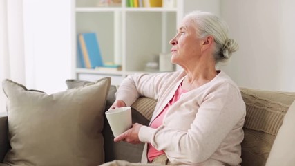 Wall Mural - senior woman with cup of tea or coffee at home