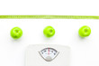 © 9dreamstudio - Bathroom scale, measuring tape and apples on white background top view