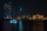 Fototapeta Londyn - Abu Dhabi buildings skyline from the sea at night
