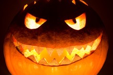 Fat Big Halloween Pumpkin Smile With Hot Burning Fire Eyes Mouth. Spooky Helloween Symbol Has Glowing Closeup Mad Face And Smiling With Sharp Teeth And Bad Look. Black Orange Nightmare Of October 31st