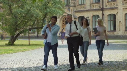 Wall Mural - Group of multi-ethnic students and teacher discussing project, walking in park