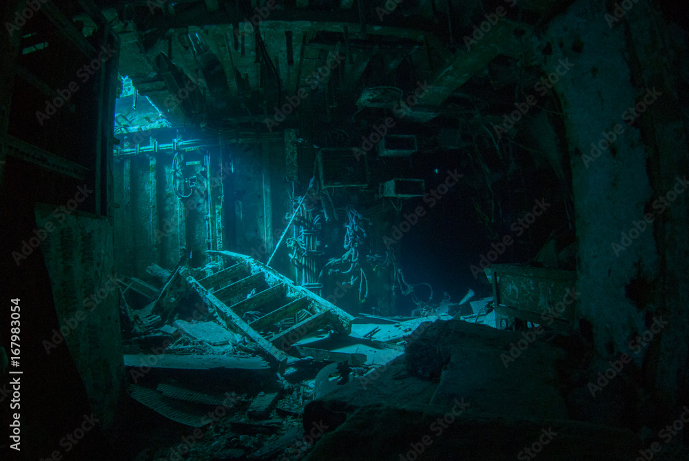 a natural light shot of the inside of the shipwreck of the captain keith tibbetts in little cayman. The inside of this room is a spooky image as the sun lights up a small section - obrazy, fototapety, plakaty 