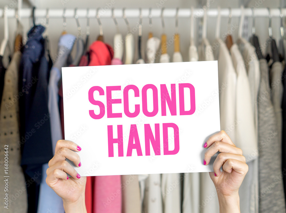 Second hand clothing shop. Used clothes hanging in hanger in a 