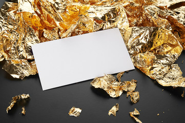 Wall Mural - Gold background. White card on the gold leaf texture isolated on black.