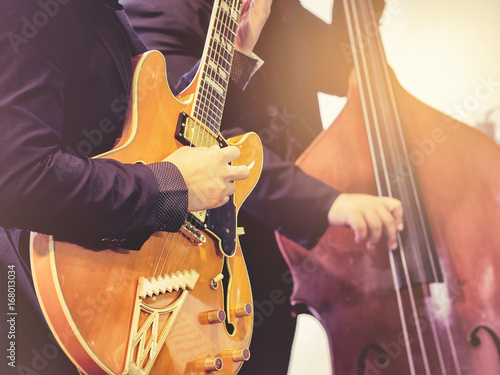 Zdjęcie XXL Muzyk grający na gitarze elektrycznej Klasyczny koncert z wiolonczelą na scenie