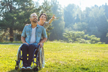 Wife Showing Something In Distance To Her Disabled Husband