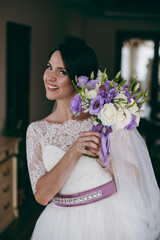 Wall Mural - Beautiful bride brunette holding a bouquet in her hands