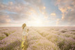 Attractive slim girl on the amazing lavender field. unrecognizable woman running into the sunset.  Romantic mood sky