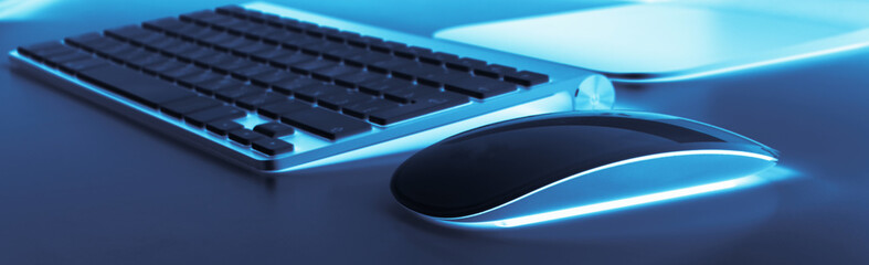 Business workplace with computer wireless keyboard and mouse on old blue table background. Office desk with copy space