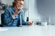 © Jacob Lund - Smiling young businesswoman working at her desk
