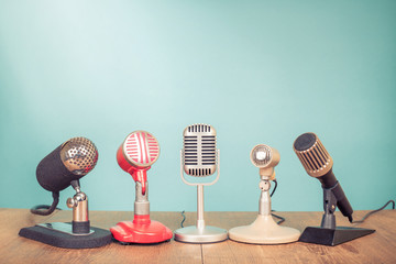 Retro old microphones for press conference or interview on table. Vintage style filtered photo