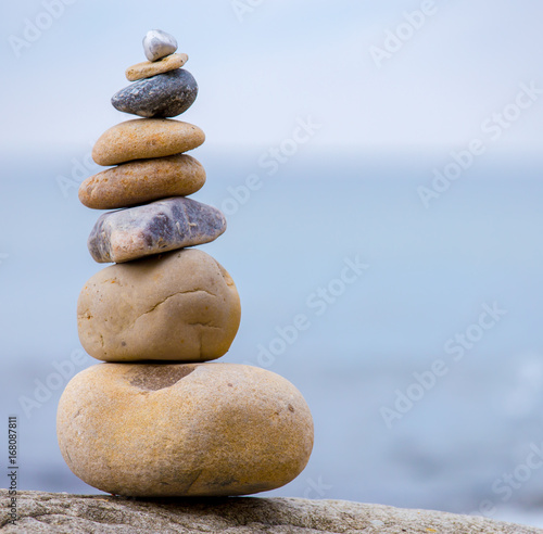 Plakat Stos okrągłych kamieni stojących na brzegu morza